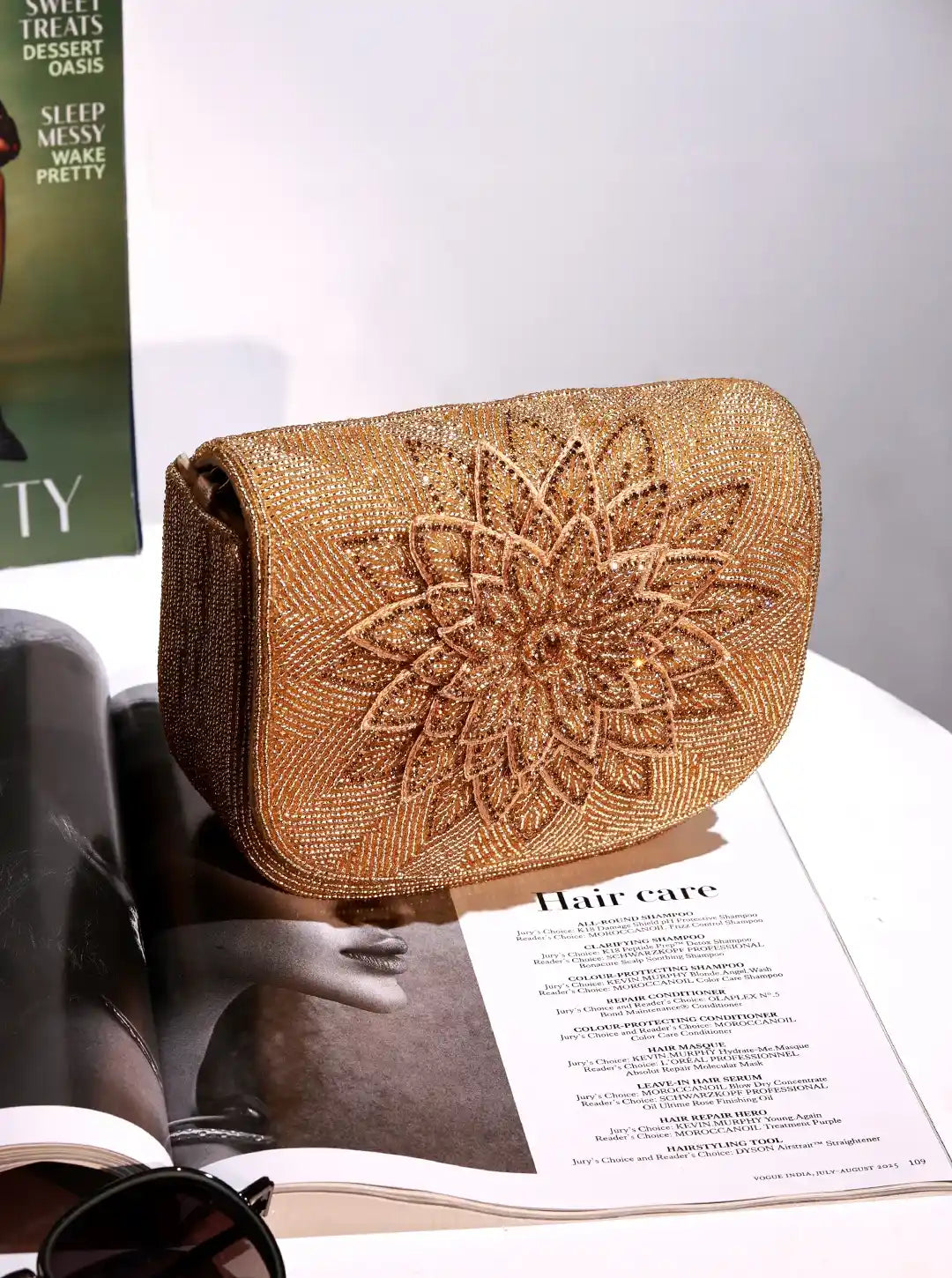 Gold beaded clutch on an open magazine with a blurred background