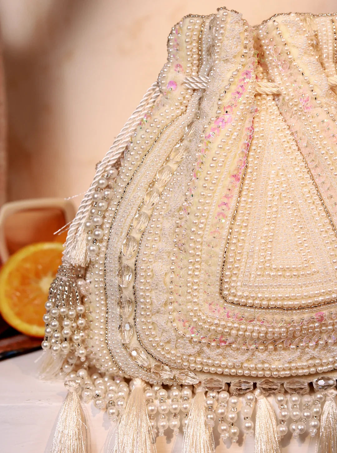 Decorative handbag with intricate beadwork and tassels on a blurred background