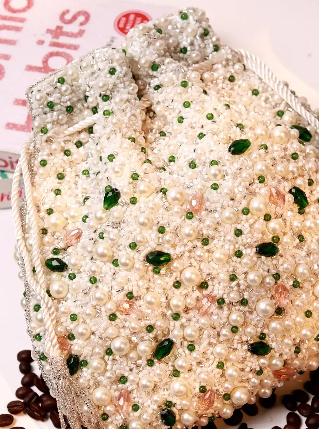 Decorative bread with pearl-like beads and green seeds on a white background