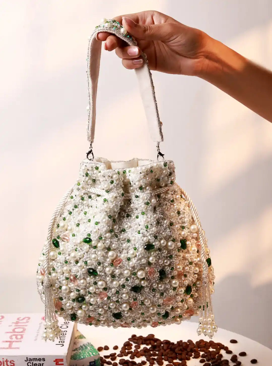 Hand holding a beaded handbag with a blurred background