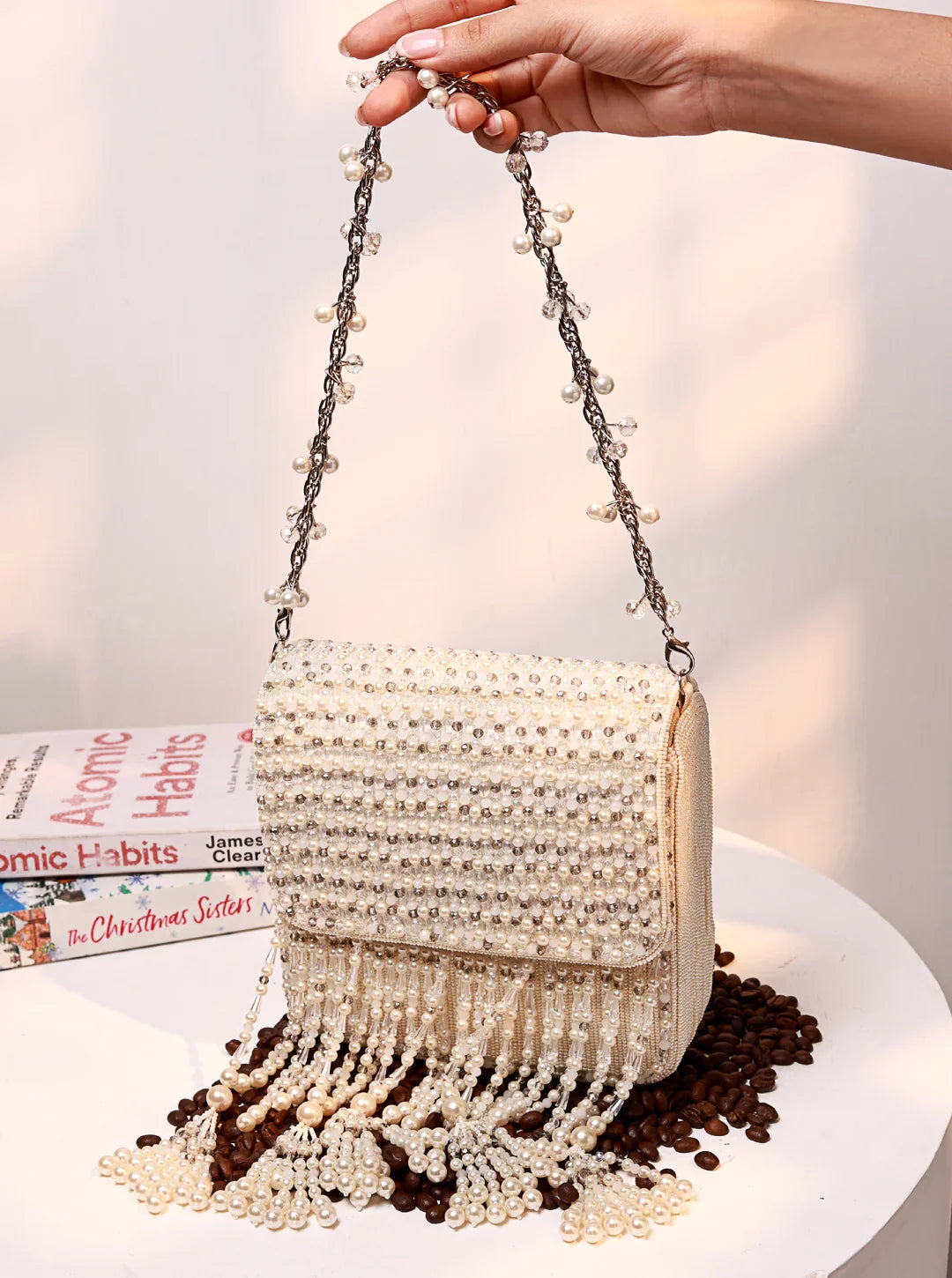 Pearl-handled handbag with fringe on a white surface