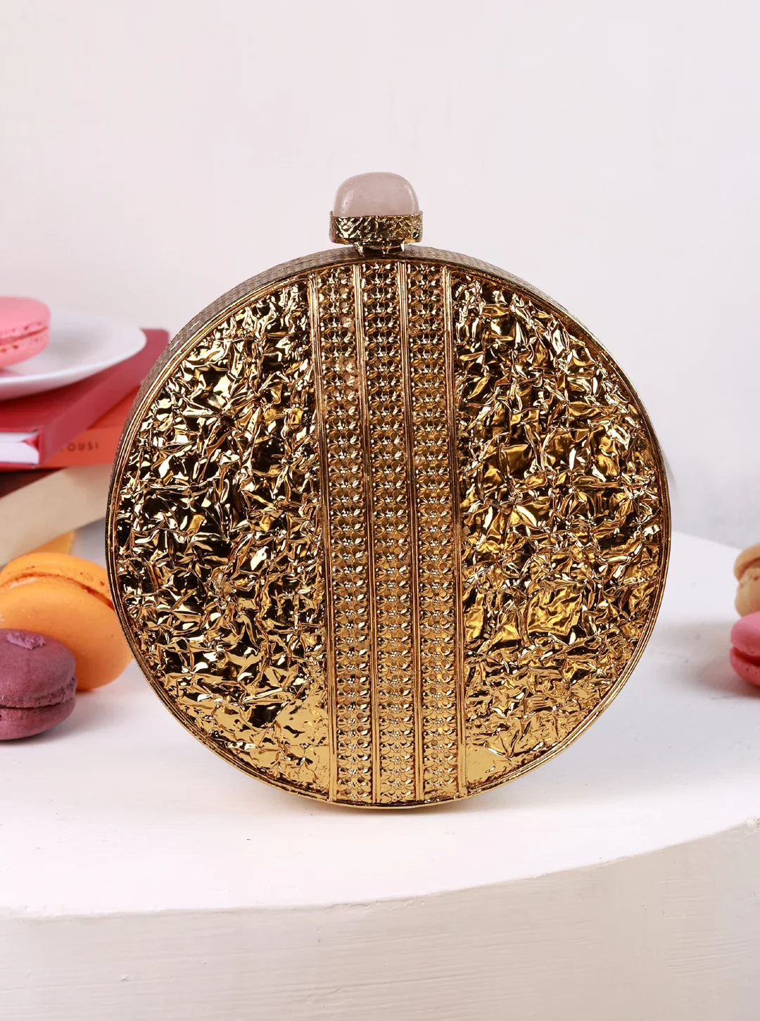 Decorative gold round clutch bag on a white background