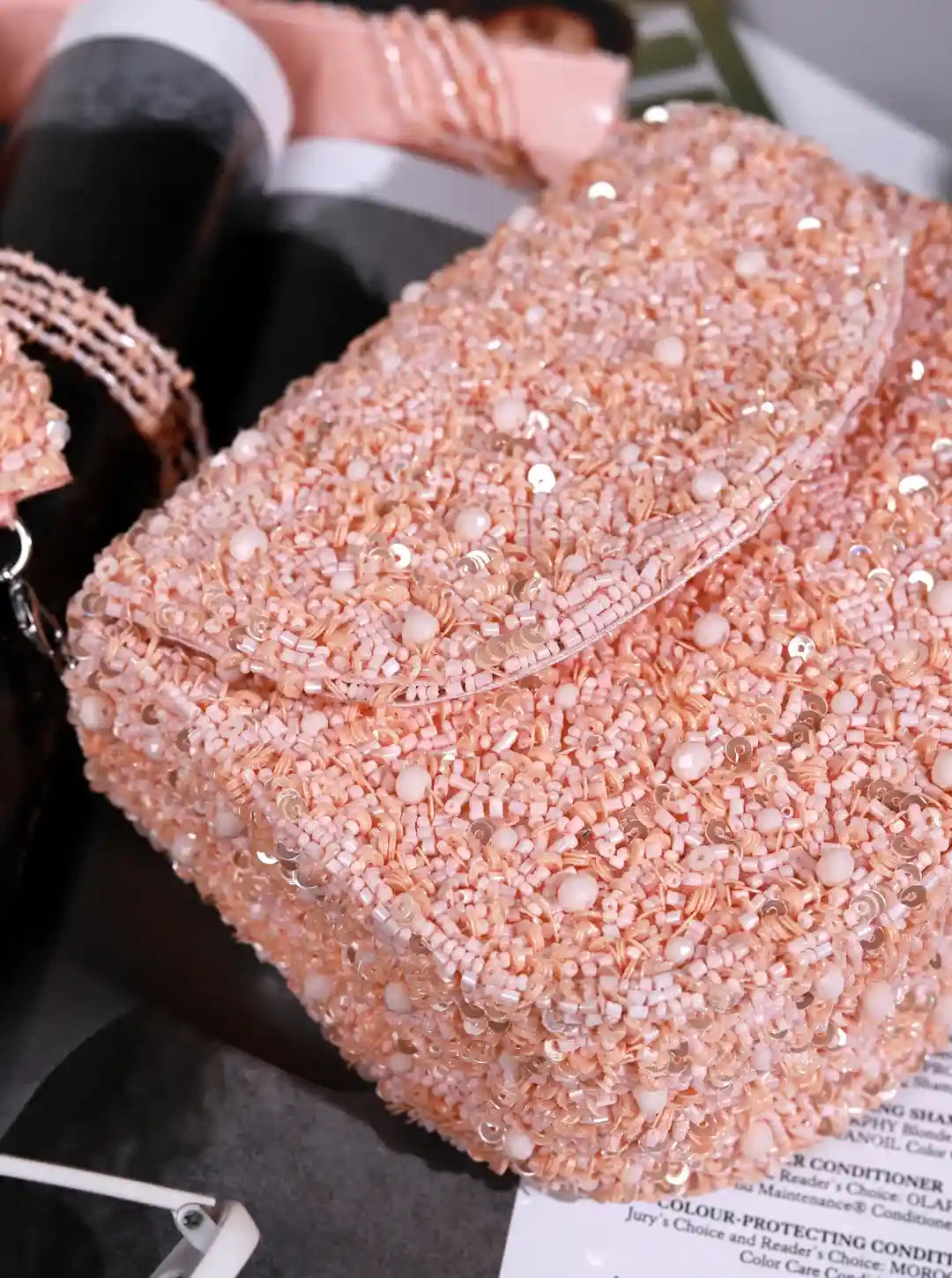 Rose gold glittery handbag on a dark surface