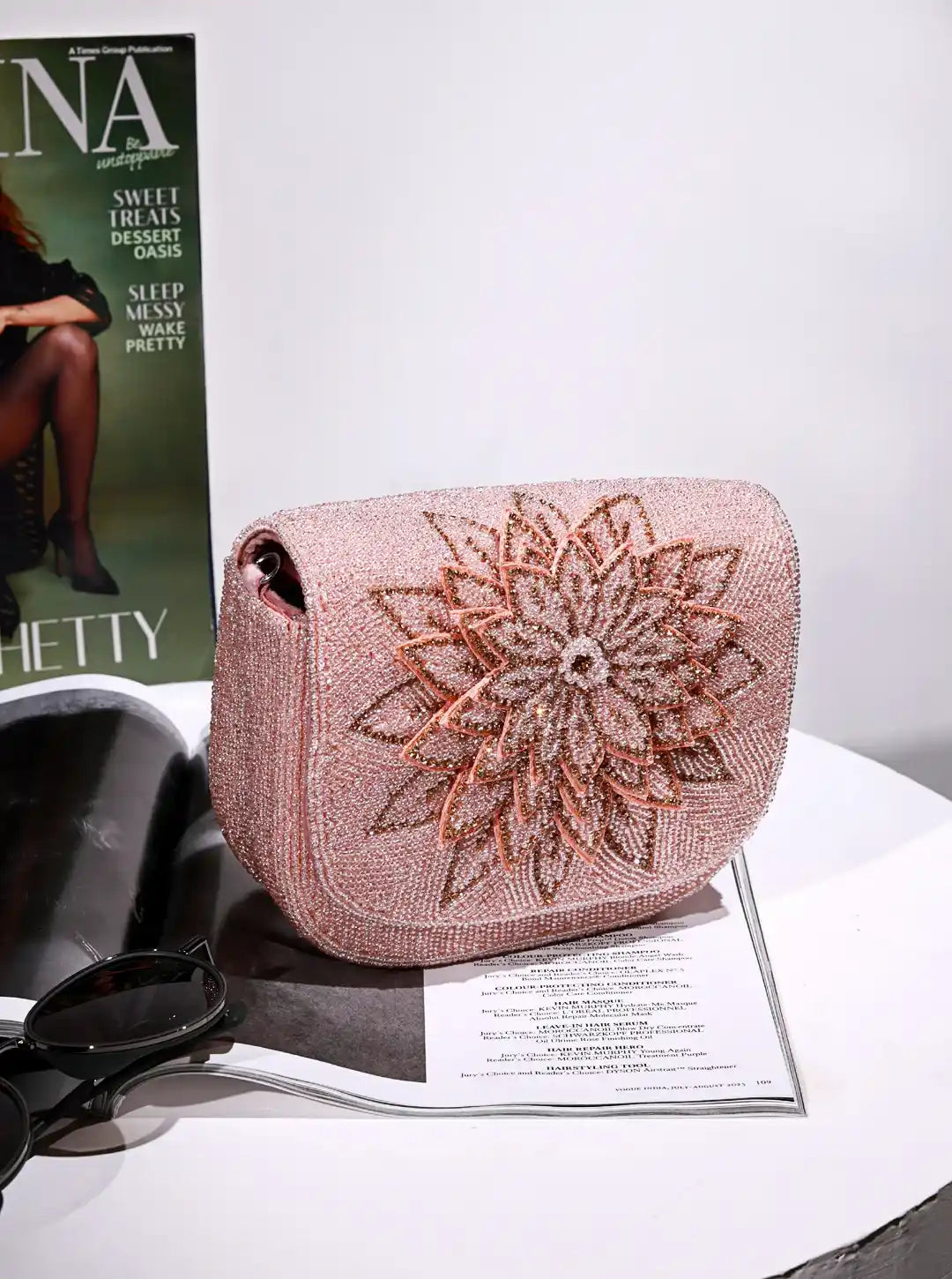 Rose gold clutch with floral design on a magazine