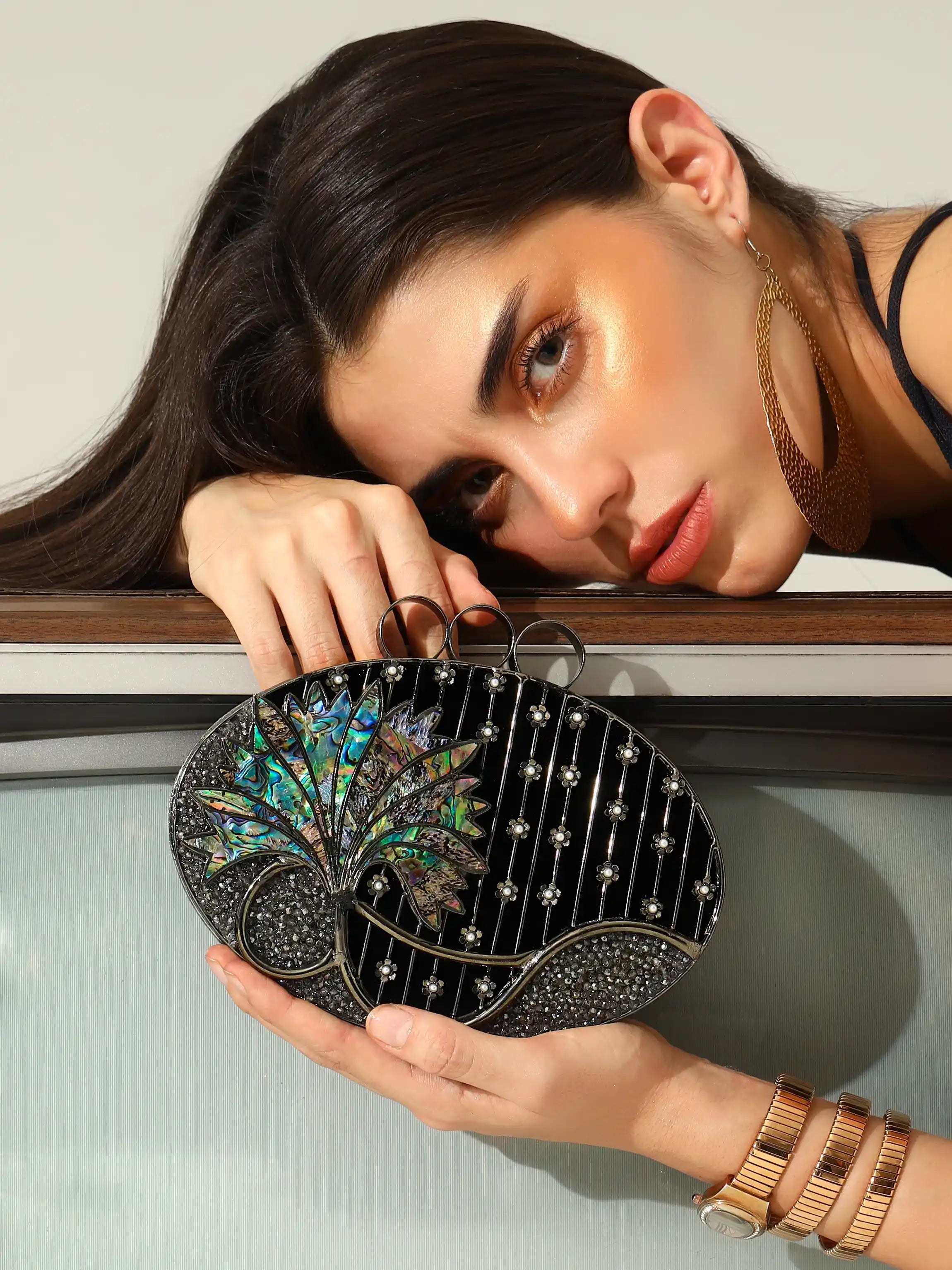 Woman holding a decorative clutch with a neutral background