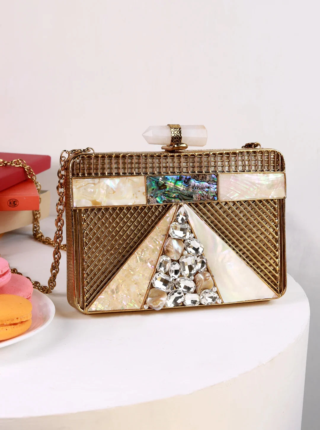 Decorative handbag with geometric design and rhinestones on a white surface