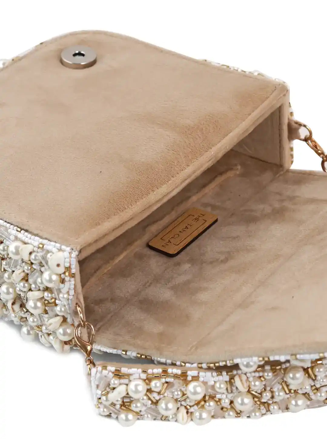 Beige handbag with pearl embellishments on a white background
