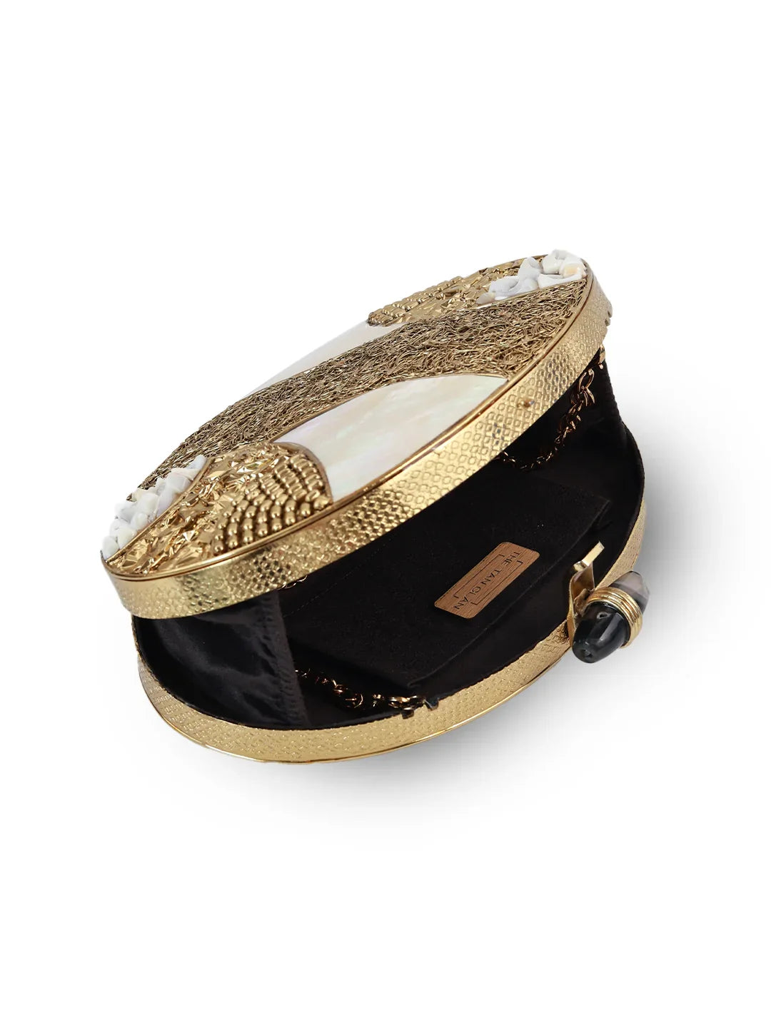 Gold and black clutch with decorative lid on a white background