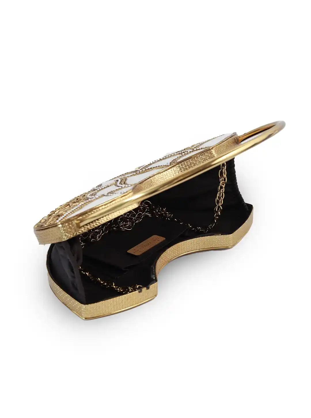 Gold and black handbag with intricate design on a white background