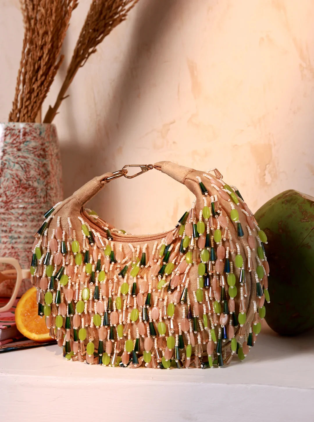 Beaded handbag with green and brown pattern on a neutral background