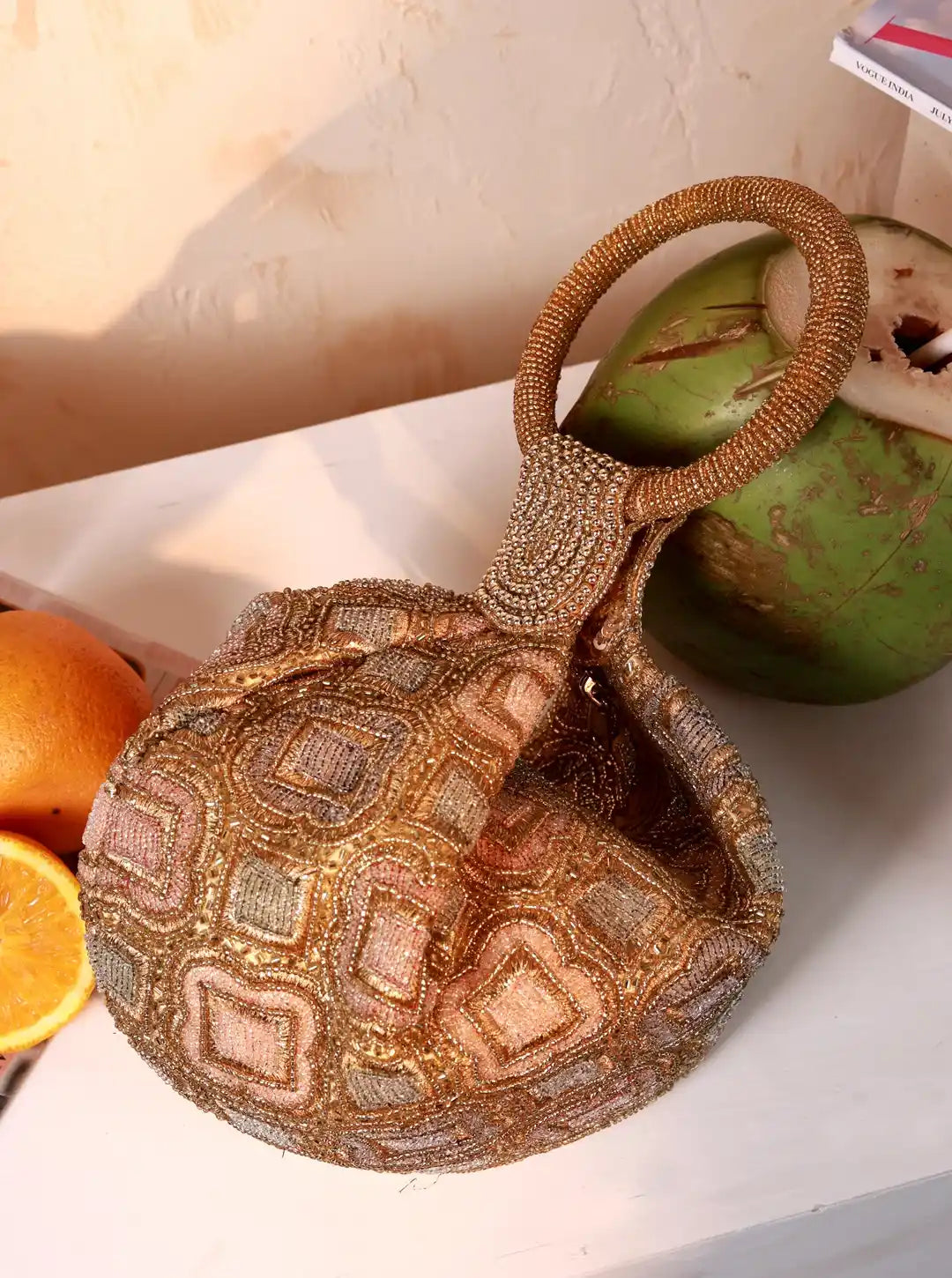 Decorative woven bag with geometric pattern on a light surface with fruits.