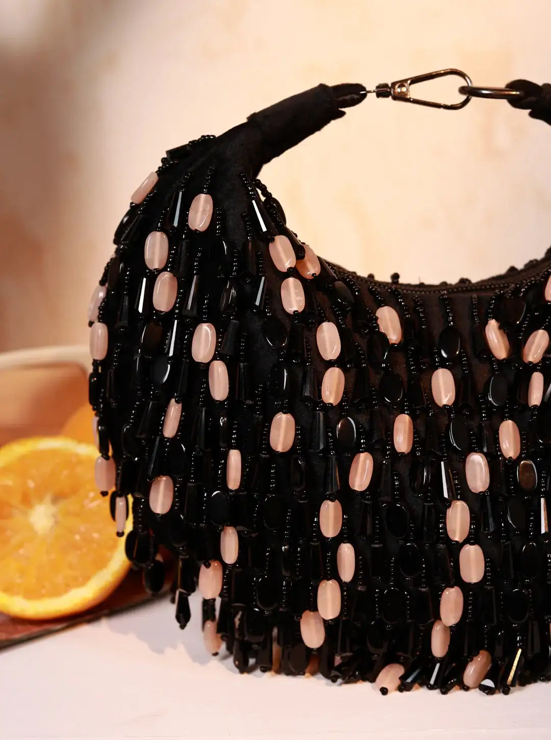 Black beaded handbag with beige beads on a blurred background