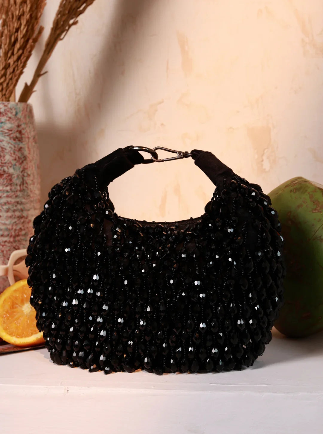 Black beaded handbag on a light background