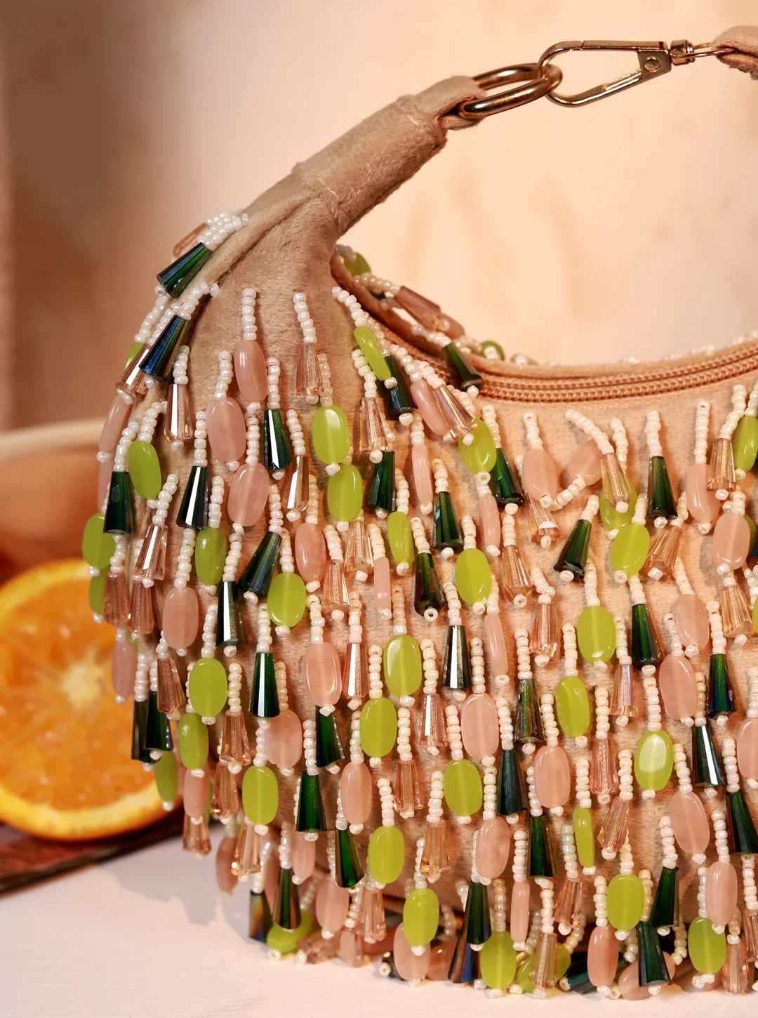 Beaded handbag with green and beige beads on a neutral background