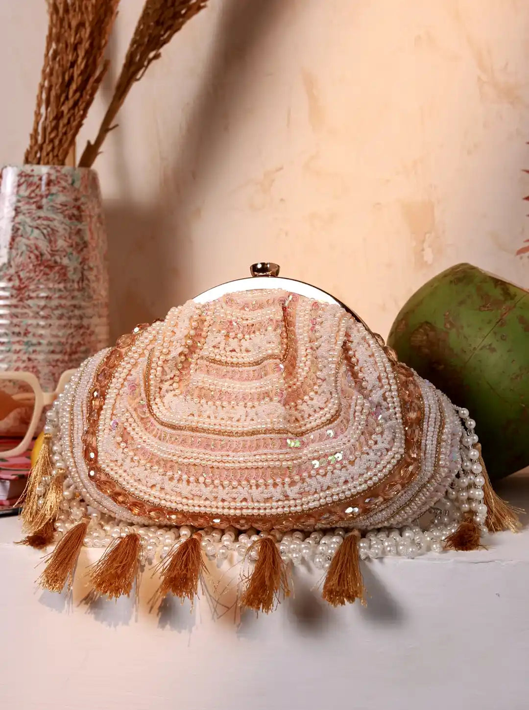Decorative round pillow with tassels and beads on a neutral background