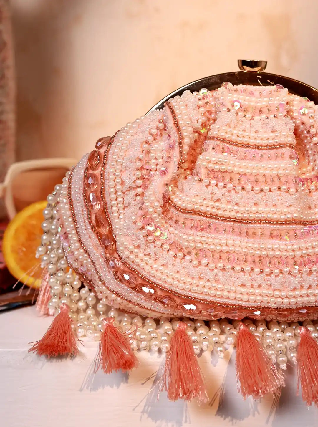 Decorative hat with beaded details and tassels on a neutral background