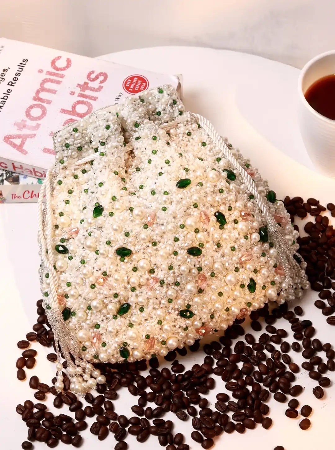 Heart-shaped cake with white frosting and green decorations on a newspaper and coffee beans