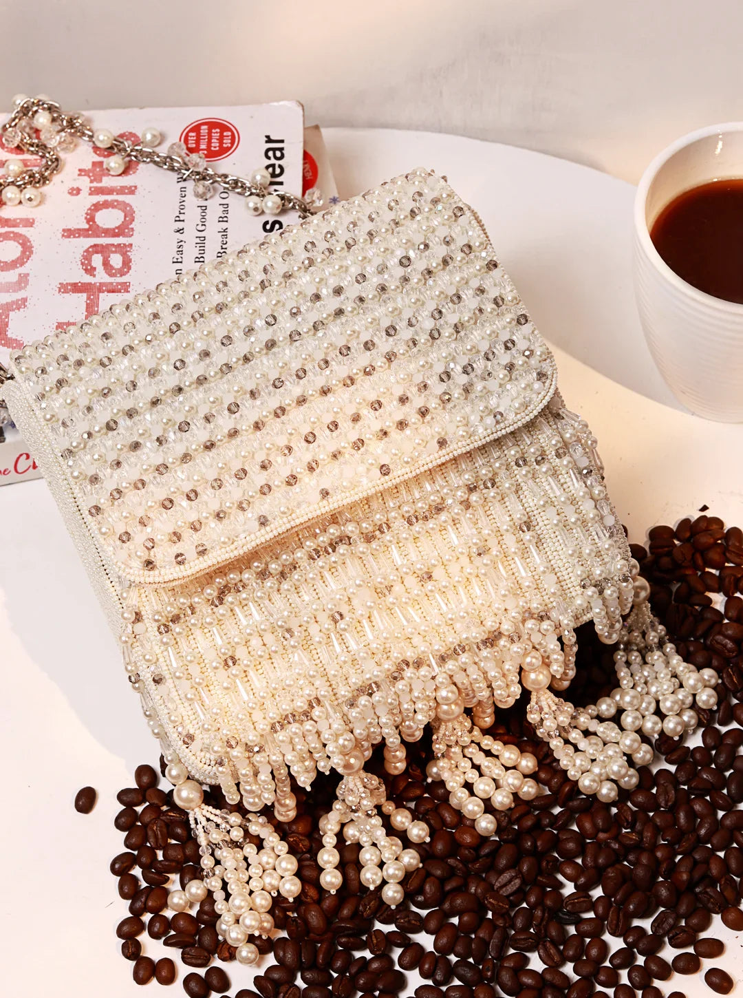 Beaded handbag on a surface with coffee beans and a book in the background