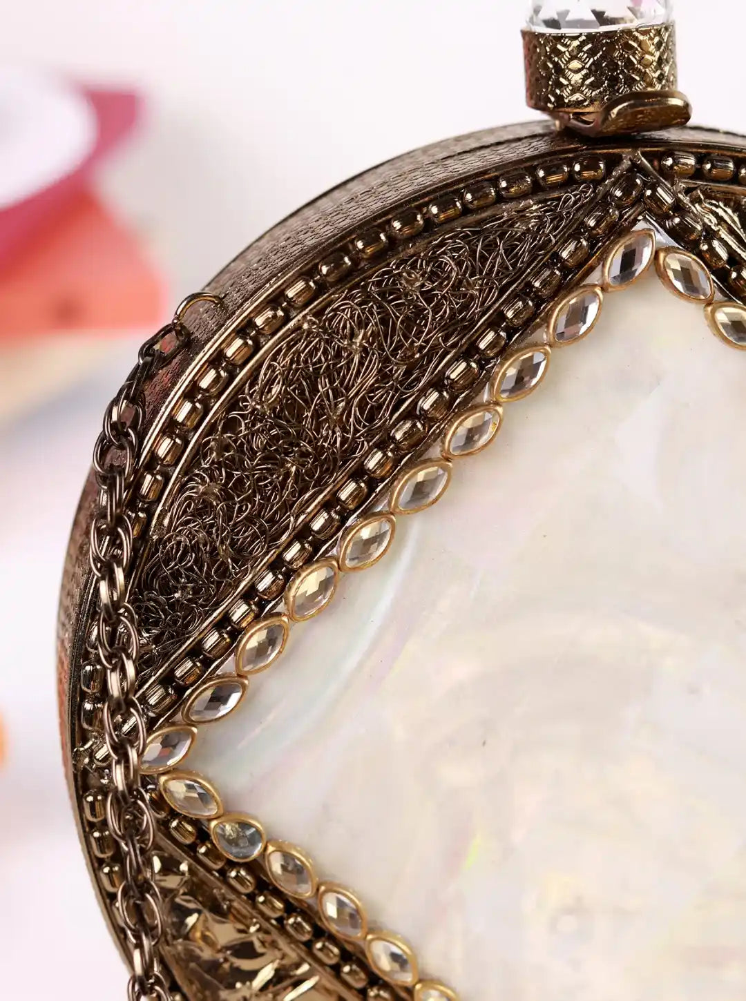 Close-up of an ornate watch face with detailed metalwork and a white center.