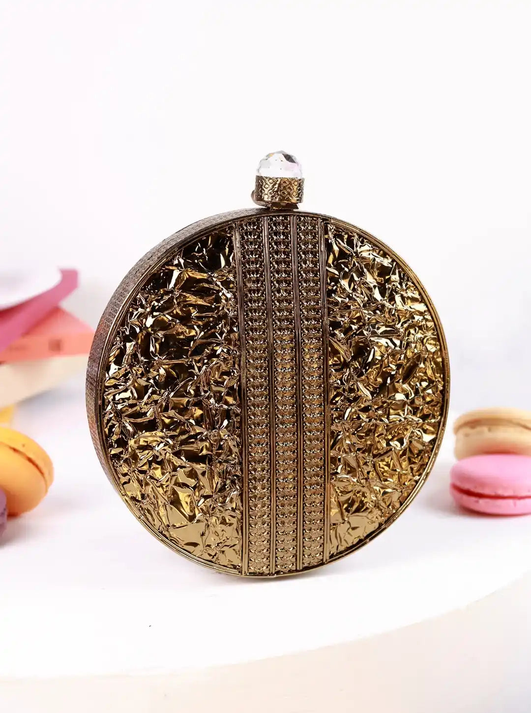 Decorative gold clutch bag with intricate patterns on a white background
