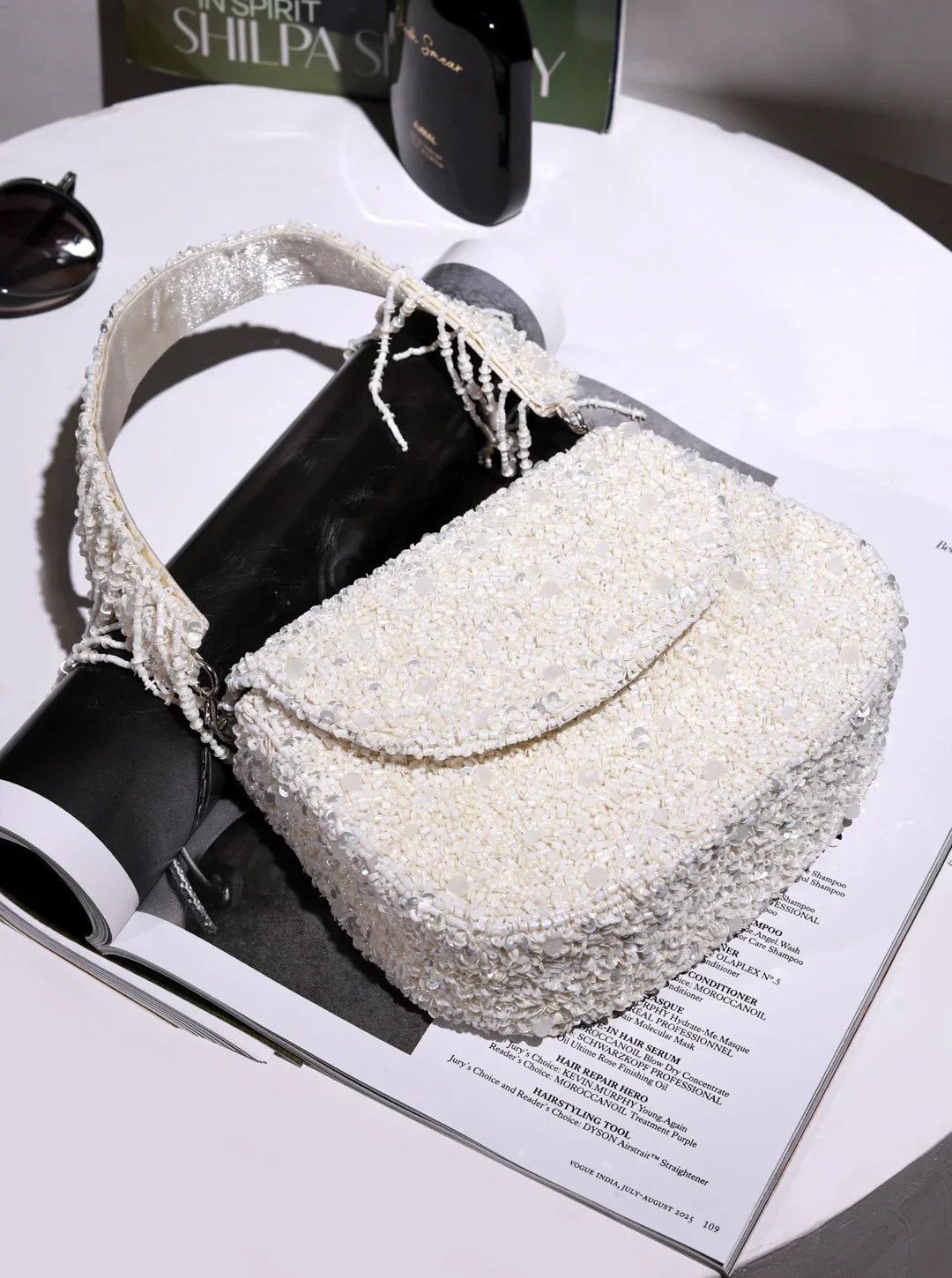 White textured handbag on a magazine with a blurred background