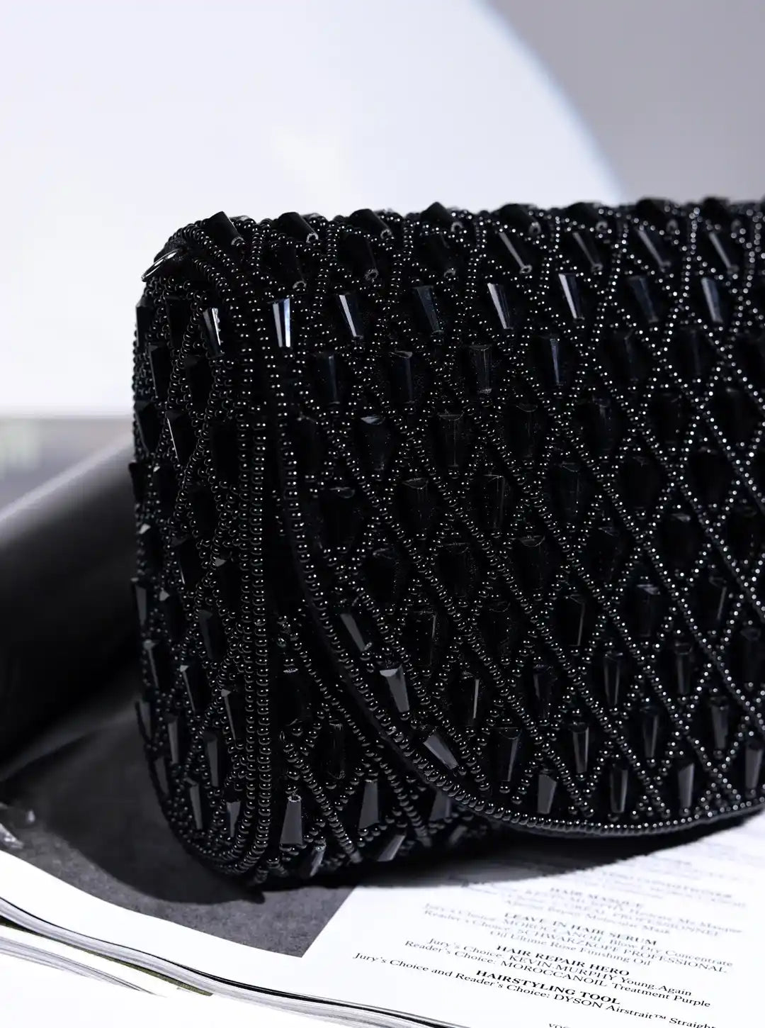 Black beaded clutch bag on a magazine