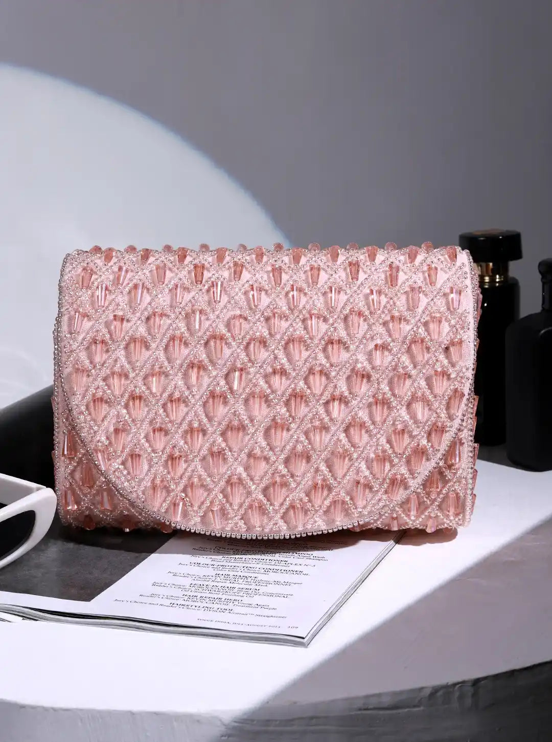 Pink textured clutch bag on a table with a blurred background