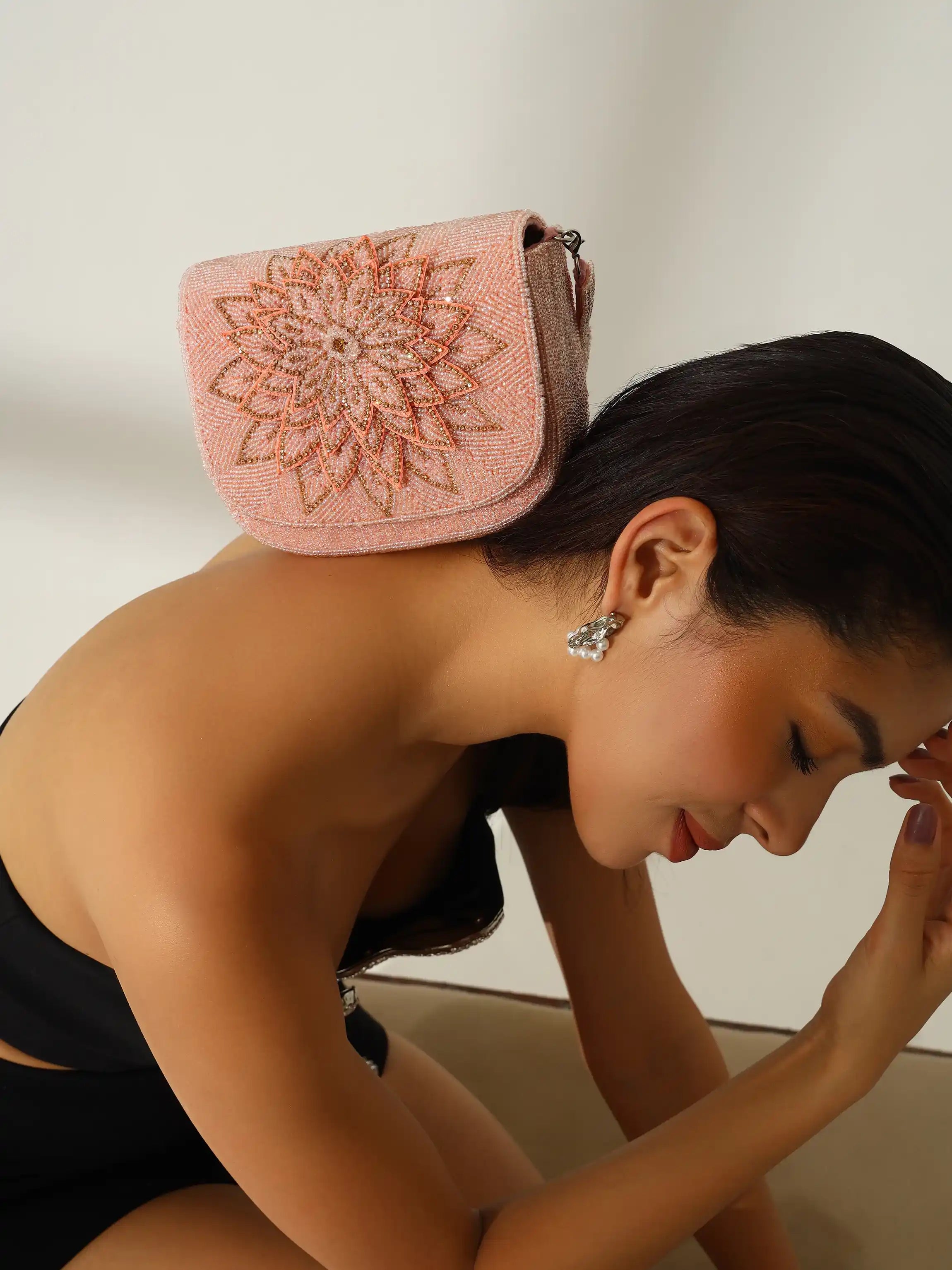 Woman with a pink decorative headscarf on her head against a plain background