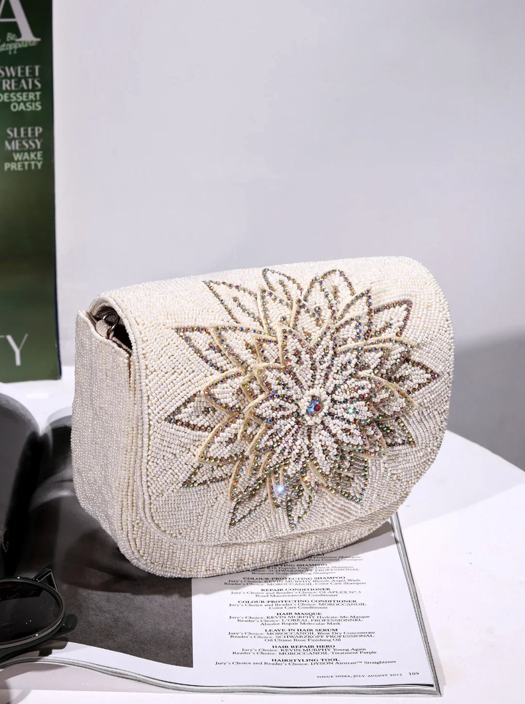 Elegant beaded clutch bag with floral design on a magazine
