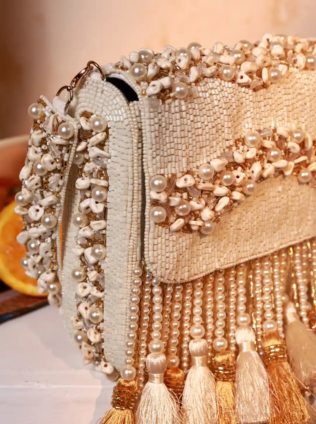 Elegant beaded handbag with tassels on a blurred background