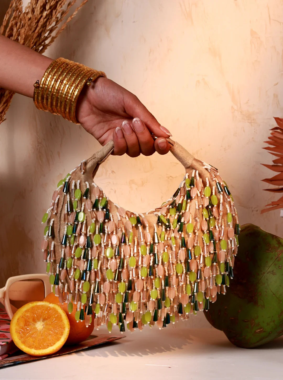 Hand holding a beaded handbag with a neutral background