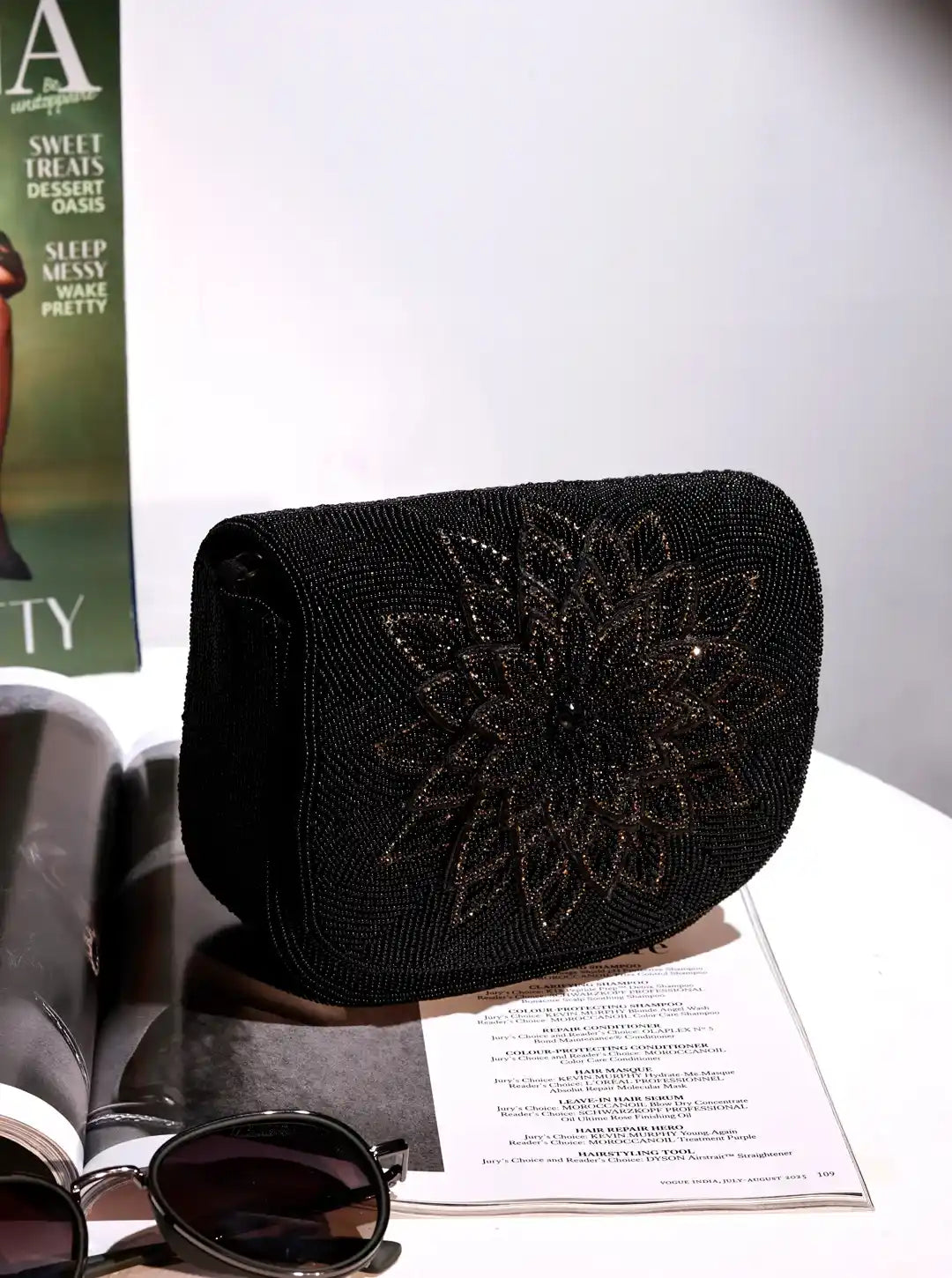 Black beaded clutch on a magazine with sunglasses