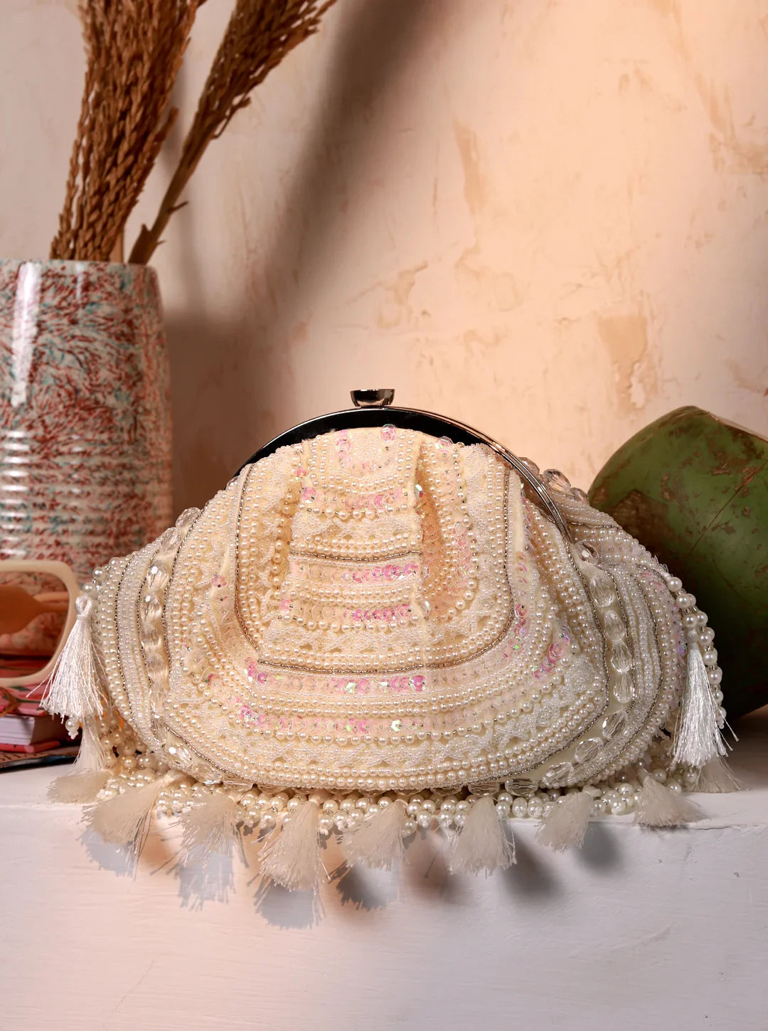 Decorative handbag with tassels and beads on a neutral background
