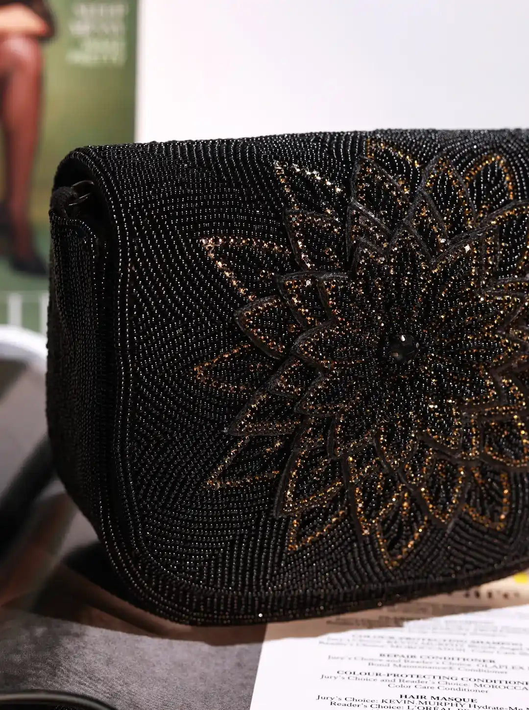 Black beaded clutch with floral design on a blurred background